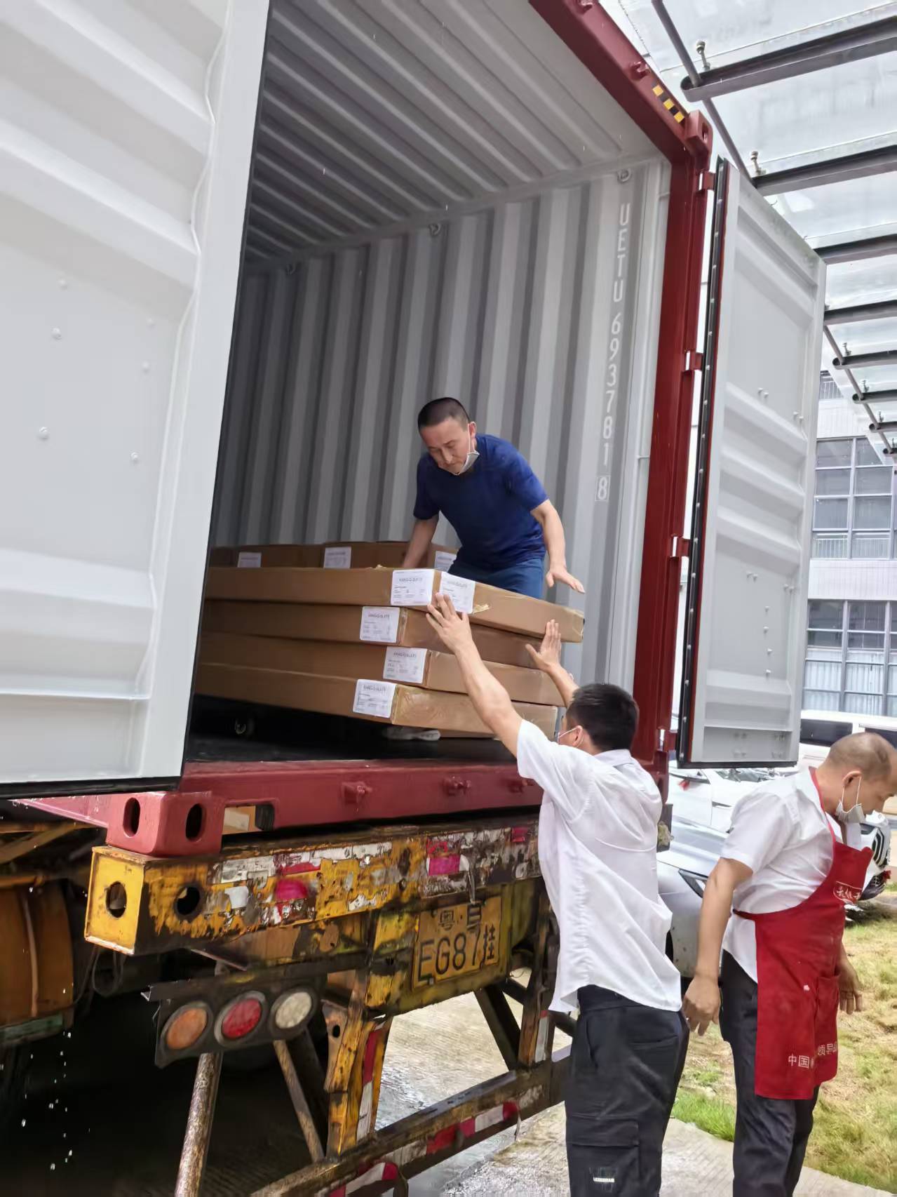 STANDEE HOME furniture cartons being loaded into a shipping container