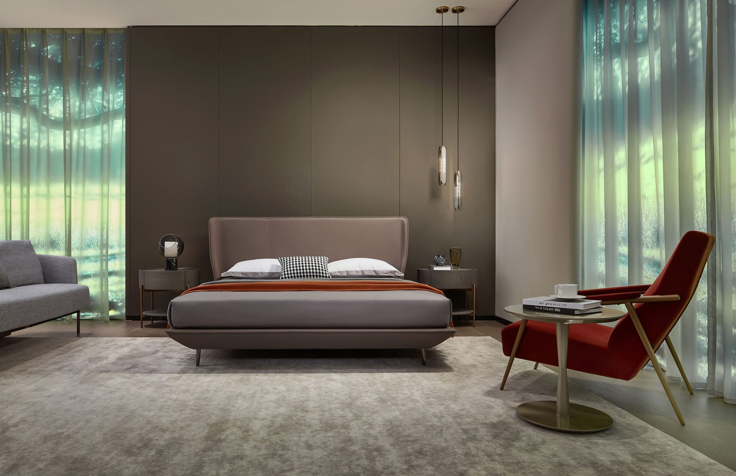 STANDEE HOME bedroom with an upholstered bed, green curtains and a red lounge chair